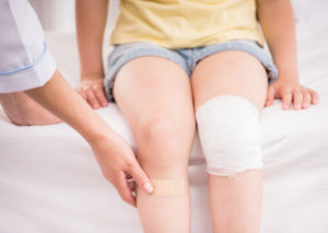 child with bandages on knees