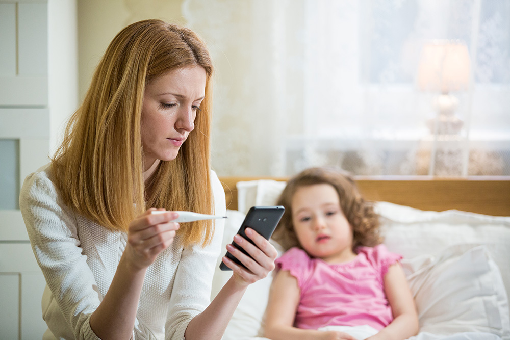 Mother making doctor appointment on phone